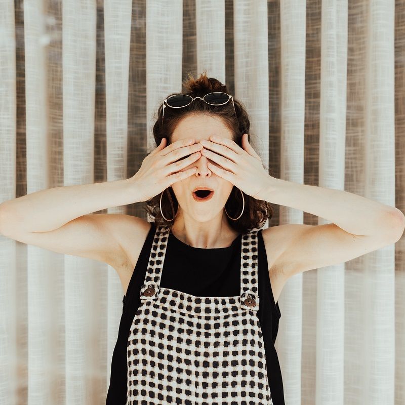 Femme surprise avec les mains sur les yeux